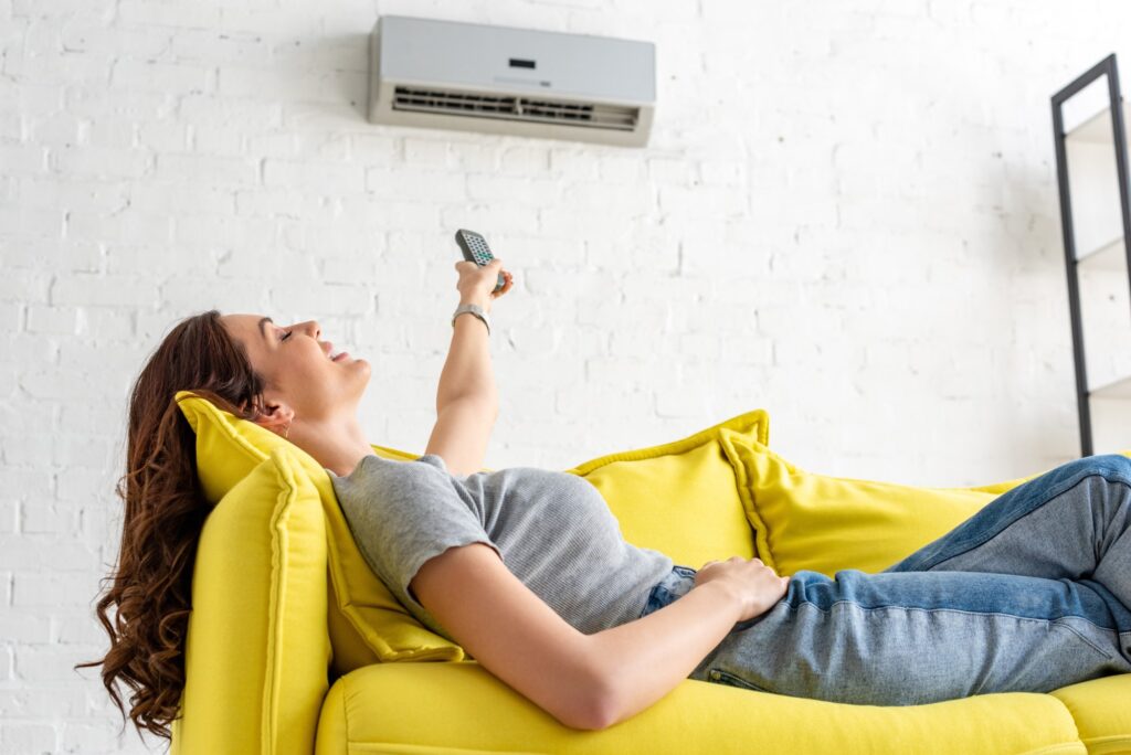 Woman laying on couch enjoying her Ductless Air Conditioner