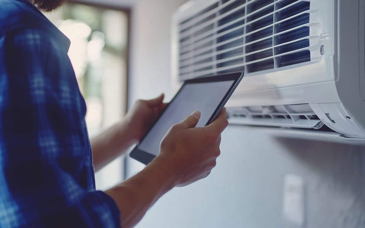 An HVAC contractor using a tablet to check an HVAC system in North Fort Myers.